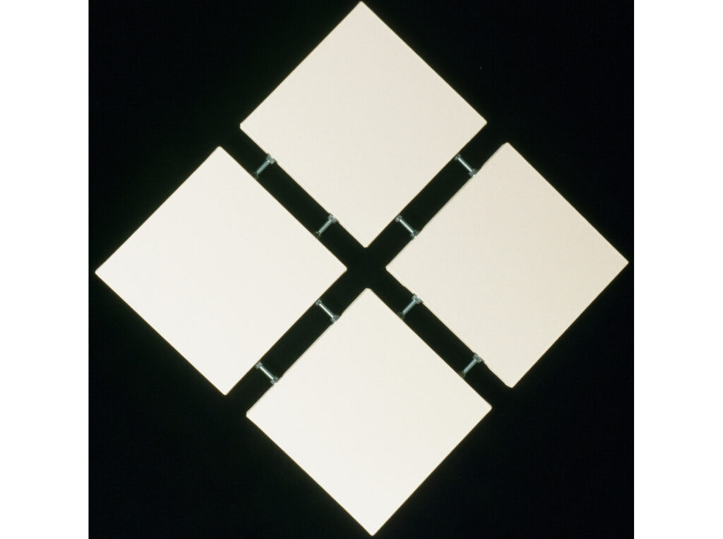 Minimalist 1998 artwork of four white square panels arranged in a diamond pattern, connected by visible metal hardware on a black background.